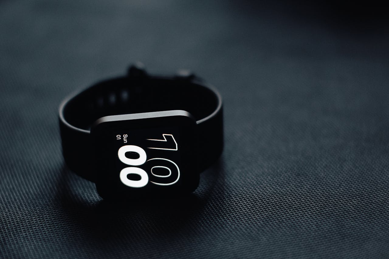 gallery-5 Modern smartwatch displaying time on a sleek dark gray surface, perfect for tech enthusiasts.