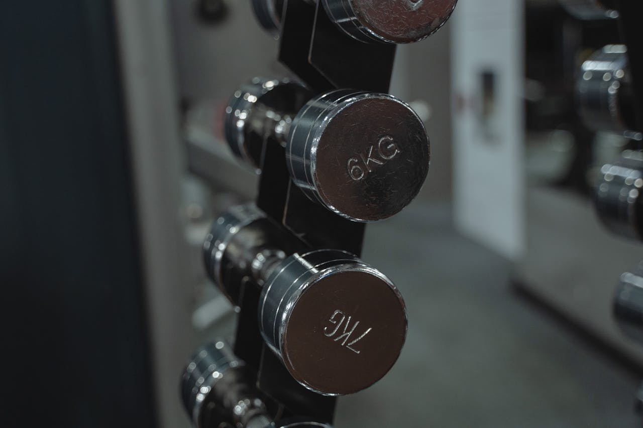 gallery-3 Metal dumbbells neatly arranged in a gym setting, ideal for fitness enthusiasts.