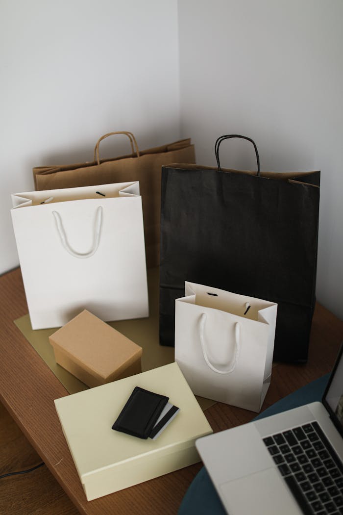 ours-journey Arranged shopping bags and laptop on a wooden table, representing online shopping.